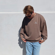 Male wearing a brown sweatshirt with Stay Golden on the left chest