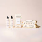 Goldie products miracle mist miracle rinse and 3-pack of probiotic wipes on a cream background